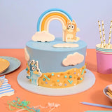 Bluey Cake by Crumbs & Doilies with Bluey and Bingo edible toppers and rainbow on blue icing.